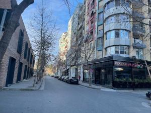 a city street with cars parked in front of buildings at Capital Apartment Tirana in Tirana