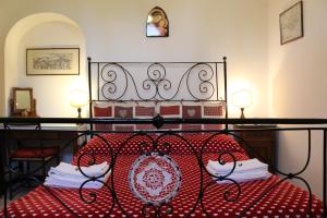 Una cama roja y blanca con libros. en La Casa Di Famiglia, en Asís