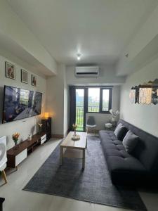 un salon avec un canapé et une télévision dans l'établissement M S Staycation, à Manille