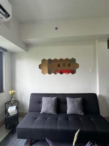 - un salon avec un canapé et un ours sur le mur dans l'établissement M S Staycation, à Manille