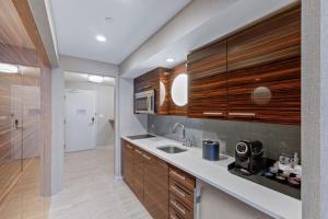 a kitchen with a sink and wooden cabinets at Stylish Oceanview Apartment Prime Location in Fort Lauderdale