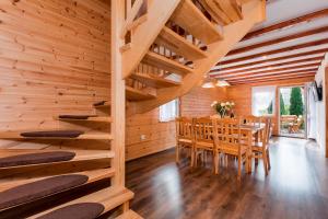 a dining room in a log cabin with a table and chairs at Bursztynek zadaszony i podgrzewany basen - 3 sypialnie 6-8 osób in Rewal