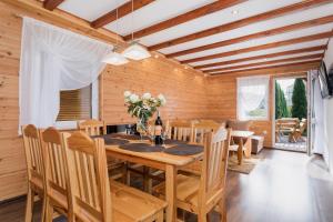 a dining room with a wooden table and chairs at Bursztynek zadaszony i podgrzewany basen - 3 sypialnie 6-8 osób in Rewal