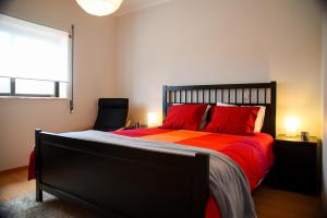 a bedroom with a bed with red pillows and a window at Midway to Geres and Braga in Amares