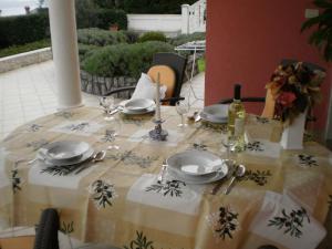 a table with a table cloth with plates and wine glasses at Villa Antonio in Opatija