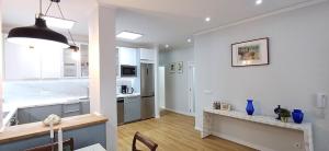 a kitchen with white walls and a table in a room at Lxroller Seomara Apartment 3 Bdr in Amadora +38 photos