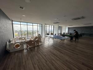 a room with ping pong tables in a building with windows at Podium Premium Homestay in Kuching