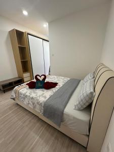 a bedroom with a bed with two red roses on it at Podium Premium Homestay in Kuching +17 photos