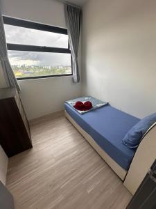 a small bedroom with a bed and a window at Podium Premium Homestay in Kuching