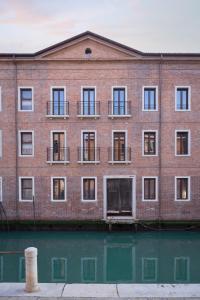 a brick building with windows and water in front at Palazzo dei Guardiani in Venice