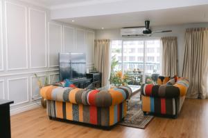 a living room with two couches and a flat screen tv at Petronella Luxury Penthouse marina court in Kota Kinabalu