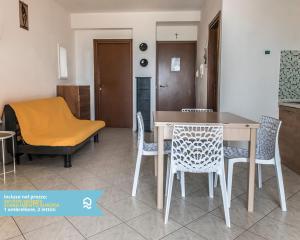 a kitchen and dining room with a table and chairs at RS315 - Marcelli, bilocale in residence fronte mare in Marcelli