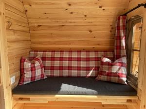 蒂门多弗施特兰德Timmi Lake的小屋内的一张床位,配有两个红色枕头