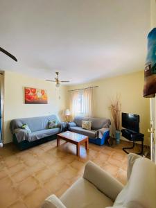 a living room with a couch and a tv at Casa Sierra in La Puerta de Segura
