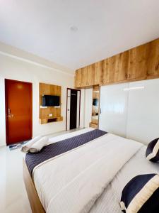 a large bedroom with two beds and a flat screen tv at 4BHK Sai Grand Villas and Hotel Near Bangalore Airport in Muthugadahalli +41 photos