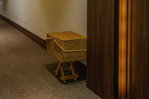 a wicker stool in a room with a wall at Maison de Onu Gwangju Cheomdan in Gwangju