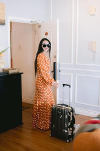 a woman in a polka dot dress with a suitcase at Petronella Luxury Penthouse marina court in Kota Kinabalu