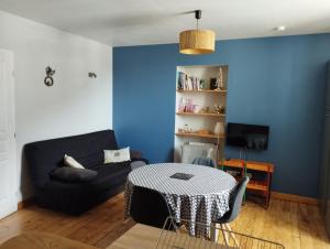 a living room with a black couch and a table at Appartement de charme à la montagne in Ax-les-Thermes