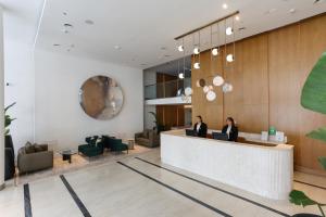 two people sitting at a reception desk in a lobby at Recoleta Grand, Buenos Aires, a Tribute Portfolio Hotel in Buenos Aires