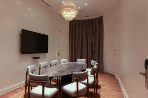 a dining room with a table and chairs and a television at Recoleta Grand, Buenos Aires, a Tribute Portfolio Hotel in Buenos Aires