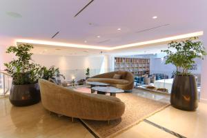 a living room with two chairs and a table and plants at Recoleta Grand, Buenos Aires, a Tribute Portfolio Hotel in Buenos Aires