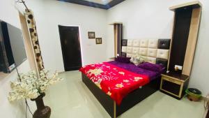 une chambre avec un lit avec une couette rouge dans l'établissement Comfy Homes- Fully Furnished Independent Floor, à Amritsar