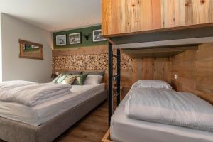 2 literas en un dormitorio con paredes de madera en Casa Te Volto, en Moena