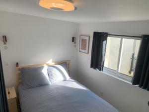 a bedroom with a bed and a window at Centre-Ville Parking Gratuit Proche Aéroport in Beauvais
