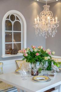 a dining room table with flowers and a chandelier at Luxus Sönshörn 20 in Munkmarsch