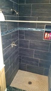 a bathroom with a shower with blue tiles at The Zen Den in Del Norte
