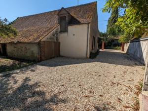 a garage with a white door and a building at Gîte rénové avec piscine dans le Gâtinais - FR-1-590-564 in Chantecoq