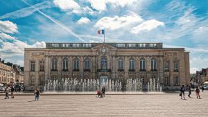 a large building with a fountain in front of it at Centre-Ville Parking Gratuit Proche Aéroport in Beauvais
