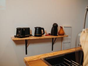 two wooden shelves on a wall with two microwaves at Studio cosy en pleine nature avec animaux admis et parking privé - FR-1-590-565 in Montbarrois