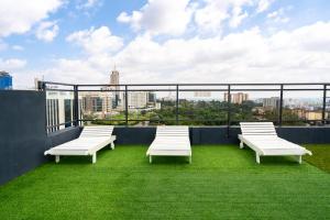 a group of white benches sitting on top of a roof at Modern 1BR Apartment in Upperhill, Nairobi in Nairobi