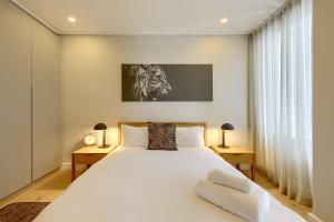 a bedroom with a large white bed with two night stands at 7 on Bantry Luxury Residence 305 in Cape Town
