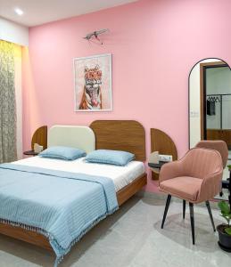 una camera da letto con un letto e una parete rosa di Calm Canopy 1BHK with PVT Balcony & Kitchen a Gurgaon