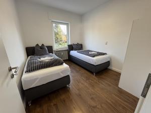 two beds in a room with a window at Ferienwohnung Arminius in Detmold