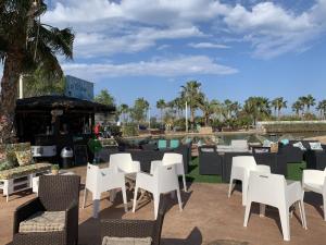 a group of white chairs and tables on a patio at Villamar 6 in San Pedro del Pinatar