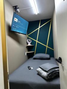 メキシコシティにあるCabina Dormitorio Polanco MP 1のベッド1台、壁掛けテレビが備わる小さな客室です。