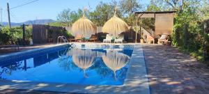 ein Swimmingpool mit Stühlen und einem Pavillon in der Unterkunft Slow House sa mayma in Nigüelas + 18 Fotos