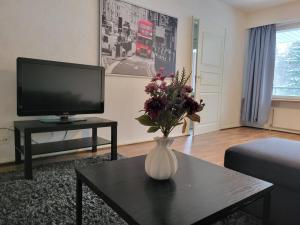 a living room with a vase of flowers on a table at After Work Escape with sauna and balcony in Joensuu
