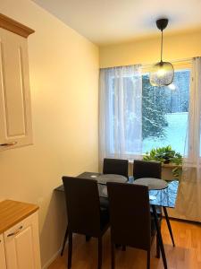 a dining room with a table and chairs and a window at After Work Escape with sauna and balcony in Joensuu +5 photos