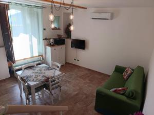 a living room with a green couch and a table at Da Giorgia in Forza dʼAgro