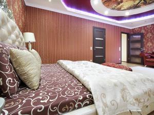 una camera da letto con un grande letto e un grande copriletto di PaulMarie Apartments on Mayakovskogo a Brest
