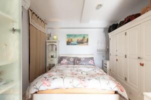 una piccola camera da letto con un letto fiorito di Les pieds dans l'eau a Virebelle