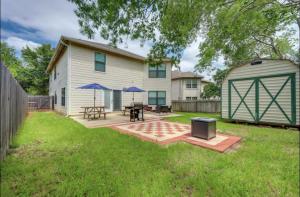 Un patio trasero con una mesa de picnic y un cobertizo. en Walk to Tx State 5 beds Firepit Grill, en San Marcos