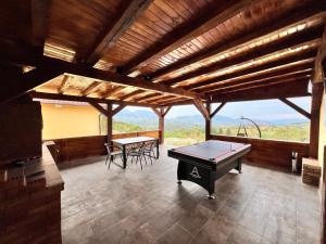 a ping pong table in a room with a view at Casa Liniștea Munților in Fundata