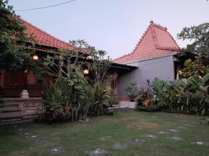 a house with a garden in front of it at Pondok Dauh Ancak Kelating Guest House in Krambitan