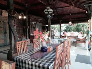 a table with a blue vase with flowers on it at Pondok Dauh Ancak Kelating Guest House in Krambitan