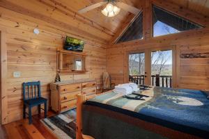 ein Schlafzimmer mit einem Bett in einer Blockhütte in der Unterkunft Whippoorwill Calling - Panoramic Mineral Bluff Cabin - Panoramic Views, Hot Tub, Nature Trail, Private Cul-De-Sac Home, Firepit, in Mineral Bluff + 173 Fotos